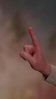 A gesturing hand is set against an artistic and visually captivating background video
