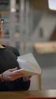 An individual in the library is engaging deeply with books and resources for learning video