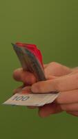 A Hand is Holding a Card Up Against a Bright Green Background Displaying Various Details video