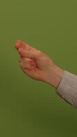 A Hand Gesture Displayed Against a Bright Green Background in a Captivating Composition video