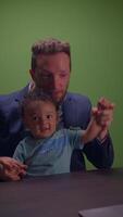 A loving father and child joyfully interact together in front of a vibrant green screen backdrop video