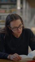 A Woman Reading a Book in a Contemporary Library Environment Filled with Resources and Ideas video