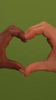 Two Hands Forming a Heart Shape Against a Bright Green Background in a Beautiful Way video