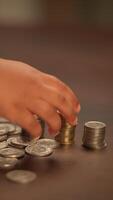 Piles of shiny coins resting on a rustic wooden table, creating a striking visual display video