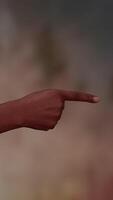This is a creative depiction of a pointing hand gesture, set against a blurred background video