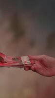 A Hand Grasping a Currency Note Set Against a Blurred Background for Contextual Display video