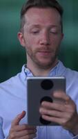 Individual actively engaging with a tablet device situated in an outdoor environment setting video