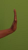 A hand gesture set against a vibrant green background, creating an abstract visual experience video
