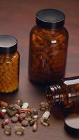 A collection of varied pills and bottles arranged neatly on a rustic wooden surface video