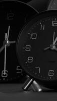 elegante negro y blanco relojes estéticamente mostrando el hora en un armonioso conducta video