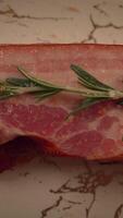 A Plate of Savory Bacon Accompanied by Fragrant Fresh Rosemary Sprigs on Rustic Wooden Background video