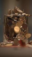 A beautiful sequence of shiny coins is falling gracefully into a glass jar container video