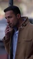 A Thoughtful and Contemplative Man is Smoking Outside While Wearing a Stylish Coat video