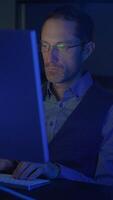 A Focused Individual Engaged in Working on a Computer Set in Dim Lighting Conditions video