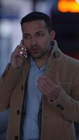 A businessman engaged in a phone conversation while situated in an urban environment video