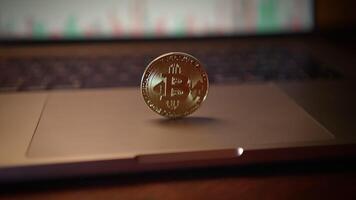 A cryptocurrency coin is prominently displayed atop a laptop keyboard, showcasing innovation video