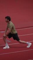 An Athlete Engaging in Stretching Exercises on the Track Surface for Improved Performance video
