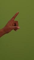 A hand gesture stands out against a vibrant green background, creating a striking visual video