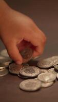 A Small Hand of a Child Is Reaching Out in a Very Engaging Manner for Coins on a Table video