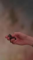 A hand is gently holding an object against a beautifully soft and blurred background video