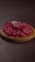 Enjoy artisanal sliced salami artfully arranged on a rustic board, ideal for entertaining video
