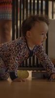 A curious little baby is happily crawling around on the floor with a playful expression video