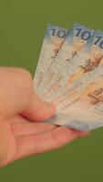 A Detailed CloseUp Image of Various Currency Notes Set Against a Vibrant Green Background video