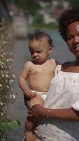 Mother and Child Embracing Joyfully by the Sparkling Water in a Beautiful Setting video