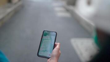 Close-up shot of a hand holding a smartphone with a map app open, showcasing a person's journey through urban streets. video