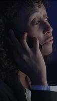 A Dedicated and Focused Professional Engaged Deeply in a Phone Call Within a Dimly Lit Office Space video