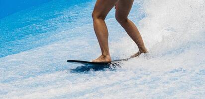 Barefoot surfer balancing on a surfboard. Water sports activity. Instructor demonstrating how to stand up on surfboard. The concept of practice and perseverance before it succeeds photo