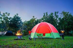 camping tent in the forest with green trees, camping in the forest at night, Small gas lantern photo