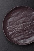Empty black ceramic plate on a dark concrete background photo