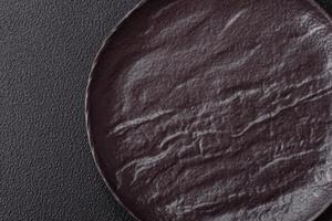 Empty black ceramic plate on a dark concrete background photo