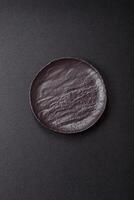 Empty black ceramic plate on a dark concrete background photo