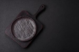 Empty black ceramic plate on a dark concrete background photo