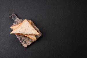 Sandwich with ham, salami, tomatoes, mustard, salt and spices photo