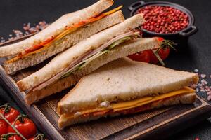 Sandwich with ham, salami, tomatoes, mustard, salt and spices photo