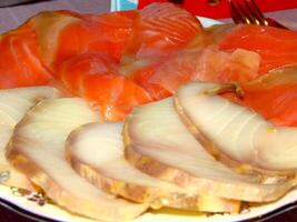 Red and white fish slices on a plate close view background photo