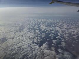 Airplane flying over white clouds background photo