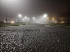 Night empty highway in mist and lamp posts lights photo