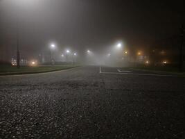 Night empty highway in mist and lamp posts lights photo