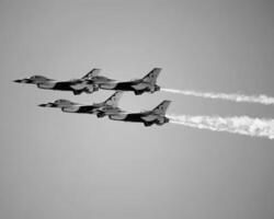 Airshow of military jet fighters. Group of military airplanes performs maneuvers with a smoke trace. Aviation background photo