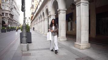 An Elegant Woman Enjoys Shopping on a Vibrant City Street with Arched Architecture video