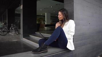 A young woman is working in a modern office setting while using her laptop for various tasks video
