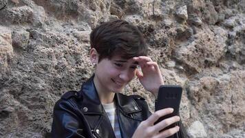 Young individuals engaging actively with their smartphones while in a vibrant urban setting video