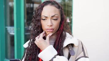 A Thoughtful Woman Using Her Smartphone While in an Urban Setting Surrounded by City Life video