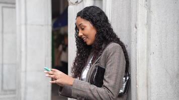 A Young Woman is Texting on Her Smartphone While in a Lively Urban Setting and Landscape video