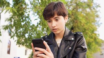 A Young Person is Deeply Engrossed in Their Smartphone While Enjoying the Outdoors video