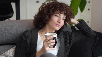 A Contemplative Woman Enjoying a Warm Drink in a Delightfully Cozy Setting and Atmosphere video